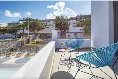 a patio with two chairs and a table on a balcony at Villa Lambis Athena in Líndos