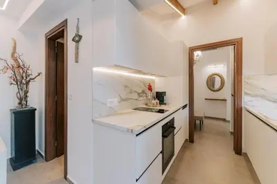 a white kitchen with a counter and a sink at La Casetta della Nonna in Lardos