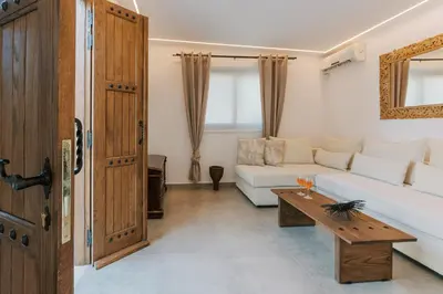 a living room with a white couch and a table at La Casetta della Nonna in Lardos