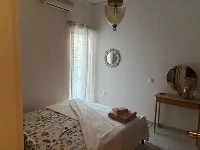 a bedroom with a bed and a mirror and a window at Rosi Rhodos in Rhodes Town