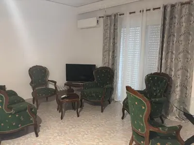 a living room with chairs and a flat screen tv at Rosi Rhodos in Rhodes Town
