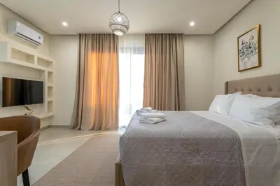 a bedroom with a bed and a tv and a window at Villa Hodaj 2 in Afantou