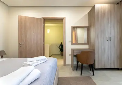 a bedroom with a bed and a desk and a chair at Villa Hodaj 2 in Afantou
