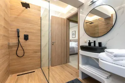 a bathroom with a shower and a sink and a mirror at Villa Hodaj 2 in Afantou