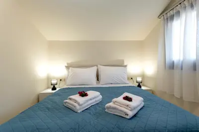 a bedroom with a bed with towels on it at Villa Hodaj 2 in Afantou
