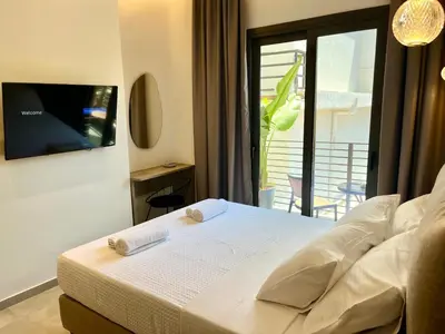 a white bed in a room with a window at Triekmo Pyr in Rhodes Town