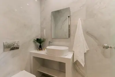 a white bathroom with a sink and a mirror at Triekmo Pyr in Rhodes Town