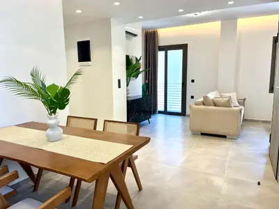 a dining room with a table and a couch at Triekmo Pyr in Rhodes Town