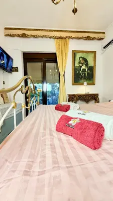 a bedroom with a bed with a red blanket on it at Popis Maison in Rhodes Town