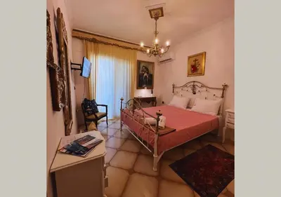 a bedroom with a red bed and a table at Popis Maison in Rhodes Town