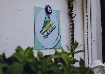 a sign hanging on a wall next to a chain at Popis Maison in Rhodes Town