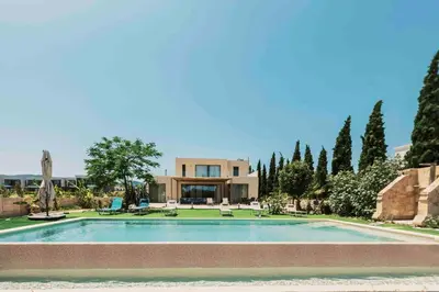 a large swimming pool in front of a house at Mythica Luxury Villa in Yennadhion