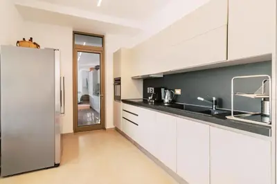 a kitchen with white cabinets and a stainless steel refrigerator at Mythica Luxury Villa in Yennadhion