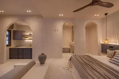 a bedroom with a couch and a ceiling fan at Kantouni Lindos ELEGANT APARTMENT in Líndos