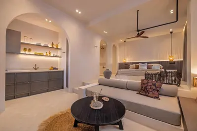 a bedroom with a bed and a couch and a table at Kantouni Lindos ELEGANT APARTMENT in Líndos