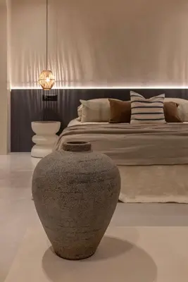 a bedroom with a large vase in front of a bed at Kantouni Lindos ELEGANT APARTMENT in Líndos
