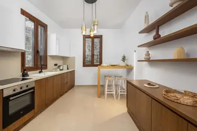 a kitchen with wooden cabinets and a counter top at Aroha Apartments in Rhodes Town