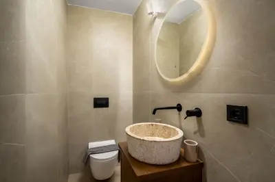 a bathroom with a sink and a toilet and a mirror at Aroha Apartments in Rhodes Town