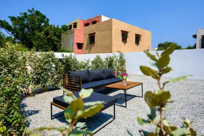 a couch and a table in front of a building at Aroha Apartments in Rhodes Town