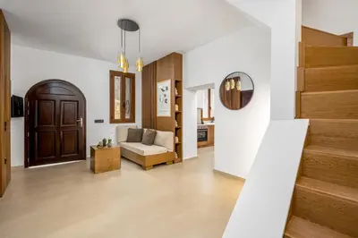 a living room with a couch and stairs at Aroha Apartments in Rhodes Town