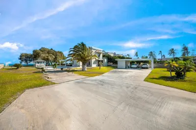 a driveway leading to a house with a palm tree at Kiotari Dream beachfront villa in Gennadi