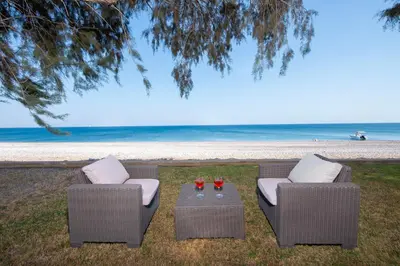 two chairs and a table in front of the beach at Kiotari Dream beachfront villa in Gennadi