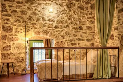 a bedroom with a bed and a stone wall at Casa Famiglia 1910 in Malona Village