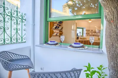 a table and chairs in front of a window at Casa Famiglia 1910 in Malona Village