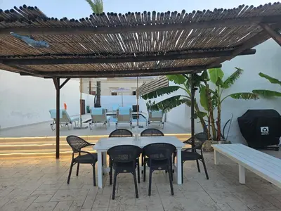 a white table and chairs under a wooden umbrella at Casa Famiglia 1910 in Malona Village