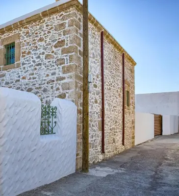 a brick building with a white fence next to it at Casa Famiglia 1910 in Malona Village