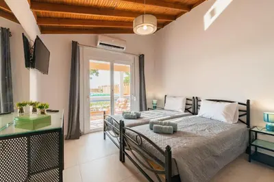 a bedroom with two beds and a large window at Casa Olive Gennadi in Gennadi