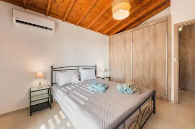 a bedroom with a large bed with towels on it at Casa Olive Gennadi in Gennadi