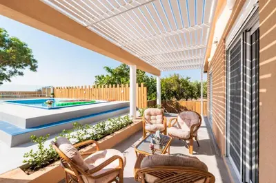 a patio with chairs and a table and a pool at Casa Olive Gennadi in Gennadi