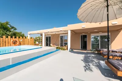 a house with a swimming pool and an umbrella at Casa Olive Gennadi in Gennadi
