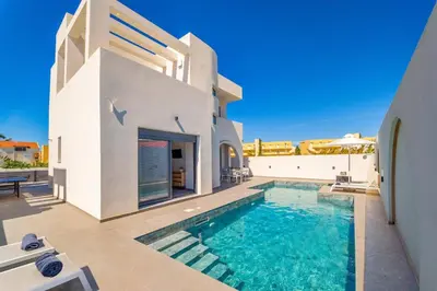 a villa with a swimming pool and a house at Villa Askim Evelia by Villa Plus in Ialyssos