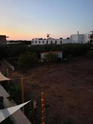 a view of a yard with a fence and a building at kiki and cocos beach house in Theologos
