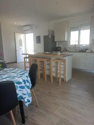a kitchen with a table and an island in a room at kiki and cocos beach house in Theologos