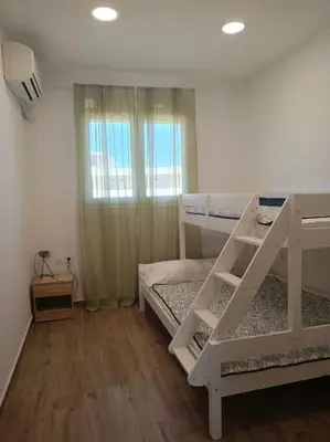 a bedroom with two bunk beds and a window at kiki and cocos beach house in Theologos