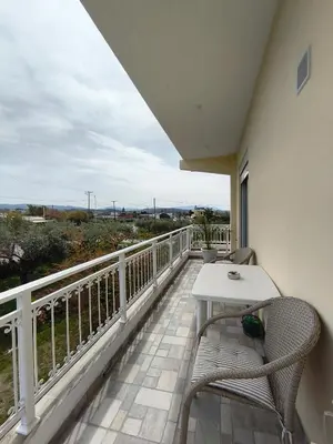 a balcony with a table and chairs and a view of the ocean at kiki and cocos beach house in Theologos