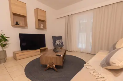 a living room with a television and a chair at Residence City Cozy Nest in Rhodes Town