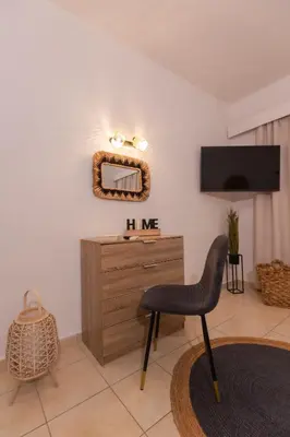 a living room with a chair and a dresser at Residence City Cozy Nest in Rhodes Town
