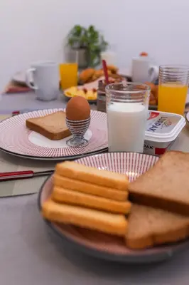 a table with a plate of bread and eggs and milk at Residence City Cozy Nest in Rhodes Town