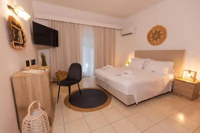 a bedroom with a bed and a chair and a television at Residence City Cozy Nest in Rhodes Town