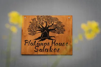 a wooden sign with a tree on a wall at Luxury Getaway with Jacuzzi - Platanos House Salakos in Sálakos