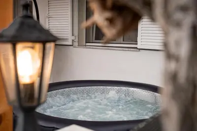 a cat is looking out of a window at Luxury Getaway with Jacuzzi - Platanos House Salakos in Sálakos