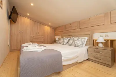 a bedroom with a large white bed and wooden cabinets at Luxury Getaway with Jacuzzi - Platanos House Salakos in Sálakos