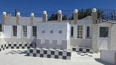 a white building with a black and white checkerboard at Castellino Studios in Faliraki