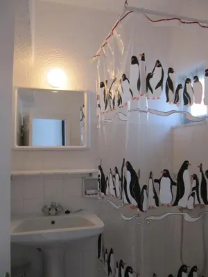 a bathroom with a shower curtain with penguins on it at Castellino Studios in Faliraki