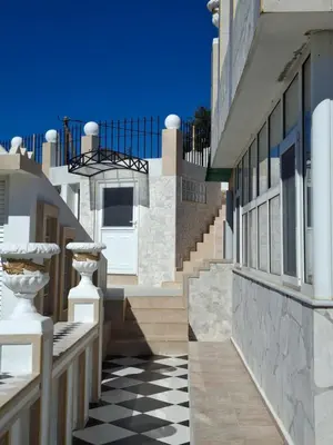 a black and white checkered floor in front of a building at Castellino Studios in Faliraki