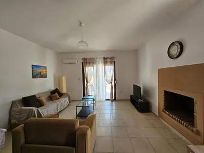 a living room with a couch and a fireplace at Villa Mare in Kiotari